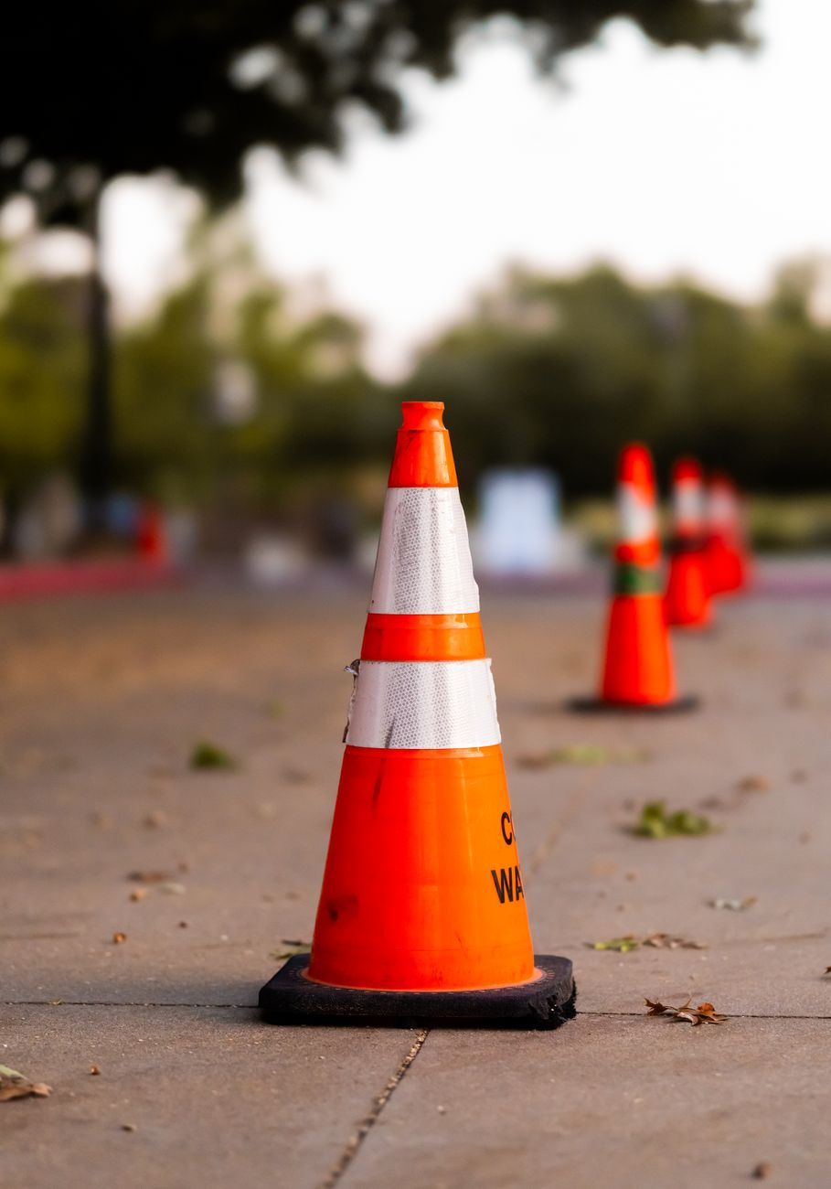Orange trafikkegler står i en række på en vej under vejarbejde